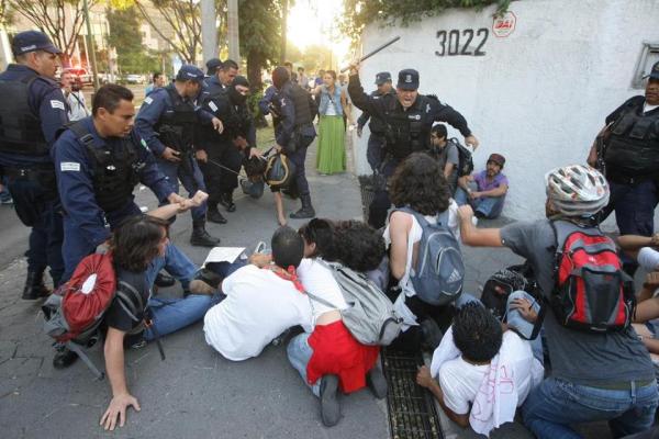 Police officers attack student demonstrators with their truncheons. Photo by Alejandro Velazco.