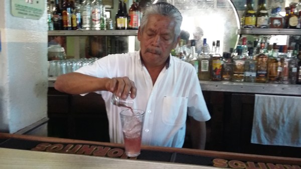 Cuco the waiter prepares the house cocktail "Nalgas Alegres" (Happy Buttocks).